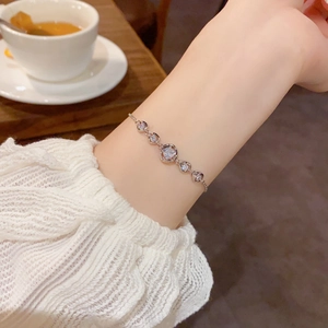 Nahaufnahme eines silbernen Armbands mit Strassherzen und runden Gliedern am Handgelenk