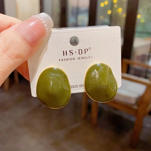 Detail of olive green irregular oval stud earrings with gold trim on S925 silver needles