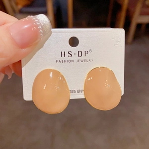 Detail of irregular cream enamel stud earrings with gold trim and 925 silver needles