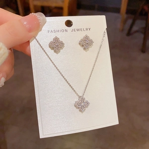 Détail d'une parure trèfle en argent avec zircons brillants sur carte de présentation