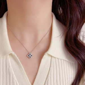 Collier trèfle de luxe en argent avec pierre verte et zircons porté par un modèle