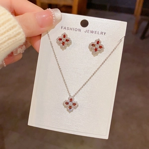 Détail de la parure trèfle à quatre feuilles sertie de zircons rouges et blancs scintillants