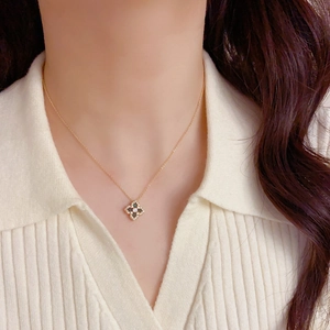 Détail du collier trèfle à quatre feuilles doré avec zircon sur le mannequin