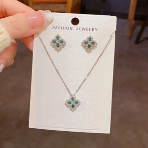 Détail de parure bijoux trèfle à quatre feuilles avec zircon vert et plaqué or