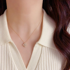 Vue détaillée d'un collier fleur à quatre feuilles doré avec zircon sur mannequin