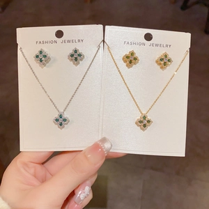 Gros plan détaillé de l'ensemble collier et boucles d'oreilles fleur à quatre feuilles en zircon