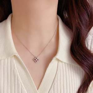Vue rapprochée du collier trèfle en argent avec zircon rouge porté par un mannequin