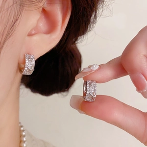 Vue détaillée de créoles argentées avec zircons pavés et motifs d'étoiles en relief