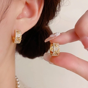 Détails de boucles d'oreilles étoiles dorées ornées de zircons et pendentif étoile