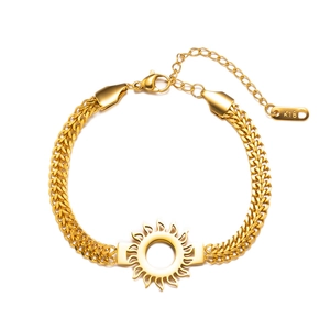 Macro detail of gold-plated sun charm and K18 engraving on layered stainless steel bracelet