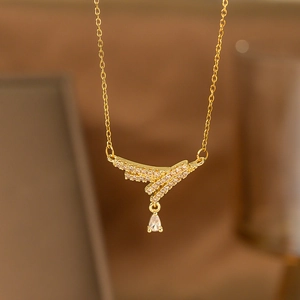 Macro shot of gold laurel wing pendant with white zircon and water drop crystal