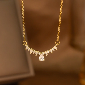 Detail of gold laurel leaf necklace featuring a pear-cut zircon and marquise stones