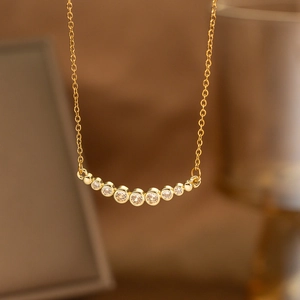 Detail of gold laurel wreath necklace with seven sparkling cubic zirconia gemstones