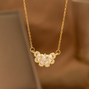 Macro detail of gold laurel wheat leaf pendant necklace with shimmering white zircon