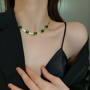 Vintage titanium necklace with five emerald stones and elegant gold wavy ring set on model