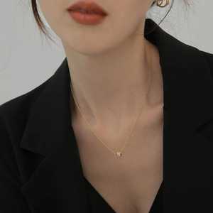 Collana minimalista in titanio oro 18 carati con diamante solitario indossata da modella