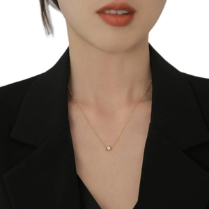 Collana minimalista in titanio placcato oro 18K con zircone solitario rotondo su modella