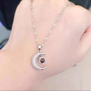 Silver crescent moon necklace with sparkling crystals and central projection stone