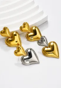Vista de detalle de pendientes de doble corazón de oro de 18k en escalones geométricos