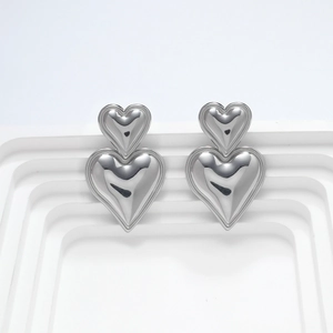 Vista macro de pendientes de corazón 3D en acero inoxidable con acabado de espejo