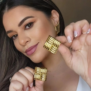 Minimalist square woven textured gold earrings with geometric 3D pattern on model