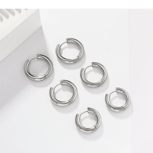 Trois paires de créoles en acier inoxydable argenté de 4 mm sur support blanc