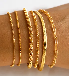 Detailed view of six 18K gold-plated stainless steel chains layered on a woman's wrist