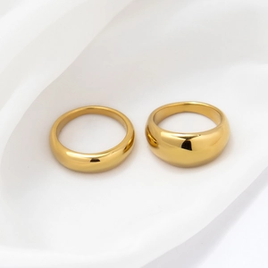 Polished 18k gold plated stainless steel dome and slim rings on white silk fabric