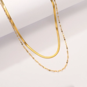 Gros plan d'un collier double épaisseur plaqué or 18 carats avec maille serpent et paillettes