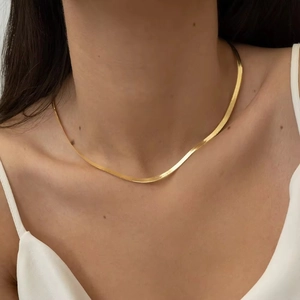 Close-up of 18K gold plated 3mm herringbone snake chain necklace on model's neck