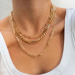 Detail of layered 18K gold plated Cuban and paperclip chains worn on a model