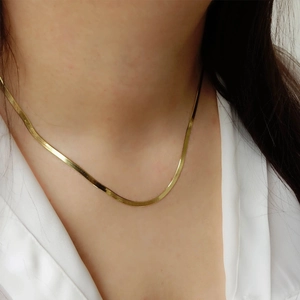 Close-up of 18K gold plated snake chain necklace showing flat texture on model's neck
