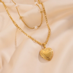 Dettaglio di una collana a due strati placcata oro 18k con ciondolo a cuore e perle