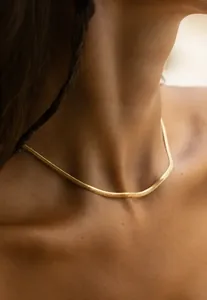 Close-up of 18K gold plated stainless steel snake chain necklace on model collarbone