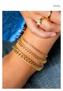 Detailed view of layered 18K gold plated Cuban link anklets with minimalist rings