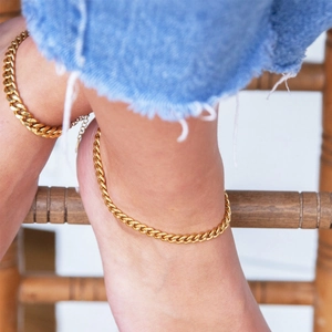 18K gold plated stainless steel Cuban link anklet worn with denim jeans on wooden steps