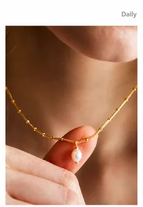 Close-up of a 18k gold plated stainless steel necklace with a teardrop pearl pendant