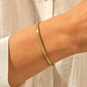 Elegante 18K vergulde roestvrijstalen visgraat slangenarmband voor dames om de pols gedragen