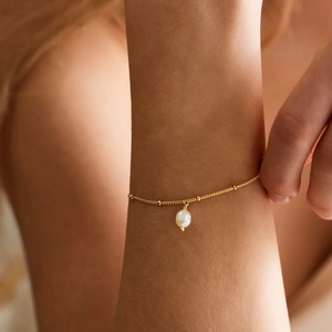 Detailed view of 18K gold plated satellite chain bracelet with a white freshwater pearl