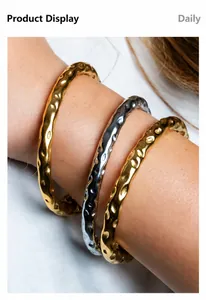 Détail de bracelets martelés en acier inoxydable plaqué or 18 carats sur le poignet