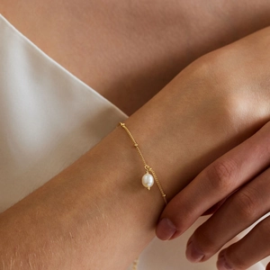 Elegant 18K gold plated stainless steel bracelet featuring a round freshwater pearl charm