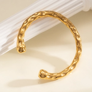 Bracelet jonc en acier inoxydable plaqué or 18 carats avec texture martelée sur colonne blanche
