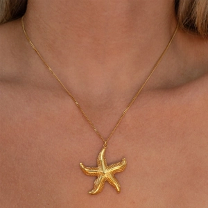 Detailed close-up of a 18k gold starfish pendant with natural textures on a chain