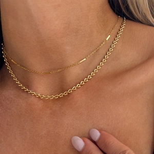 Détail du collier double couche doré avec maillons en cœur 18K et perles
