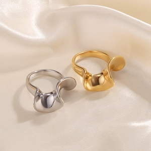 Detailed view of curved S-shape wave rings in gold and silver on champagne satin cloth