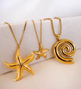 Detailed shot of 18k gold starfish and shell pendants with varied link chain textures
