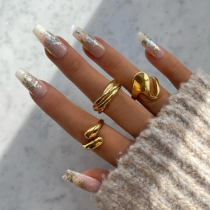 Close-up of three 18K gold plated irregular rings worn on a hand with fall fashion styling
