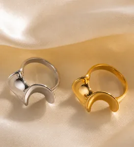 Detailed shot of S-shaped wave rings in gold and silver finish on silk fabric
