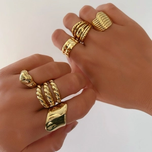 Close-up of stacked 18K gold-plated irregular rings with heart and star patterns