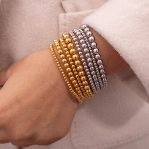 Set aus 18K vergoldeten und silbernen elastischen Perlenarmbändern im Stapel-Look
